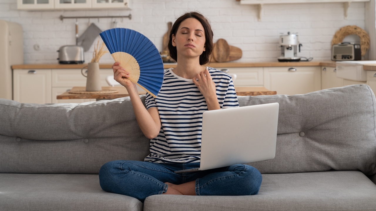 Mujer con un sofoco, uno de los síntomas de la menopausia